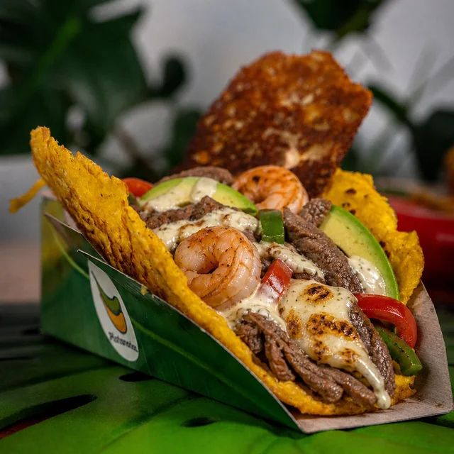 La Mar y Tierra: tostón maduro con camarón, res, salsa de ajo, queso gratinado, aguacate y pimentón