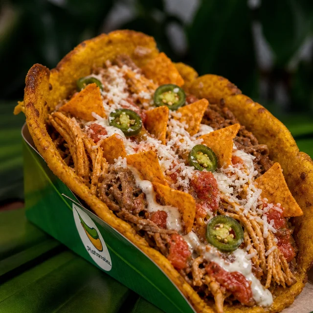 La Mexicana: tortilla maduro con cerdo, pollo, napolitana, salsa de ajo, queso rallado, Doritos y jalapeños